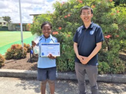 Vinnies staff member standing with Mini Vinnies Formation Program student holding up their award