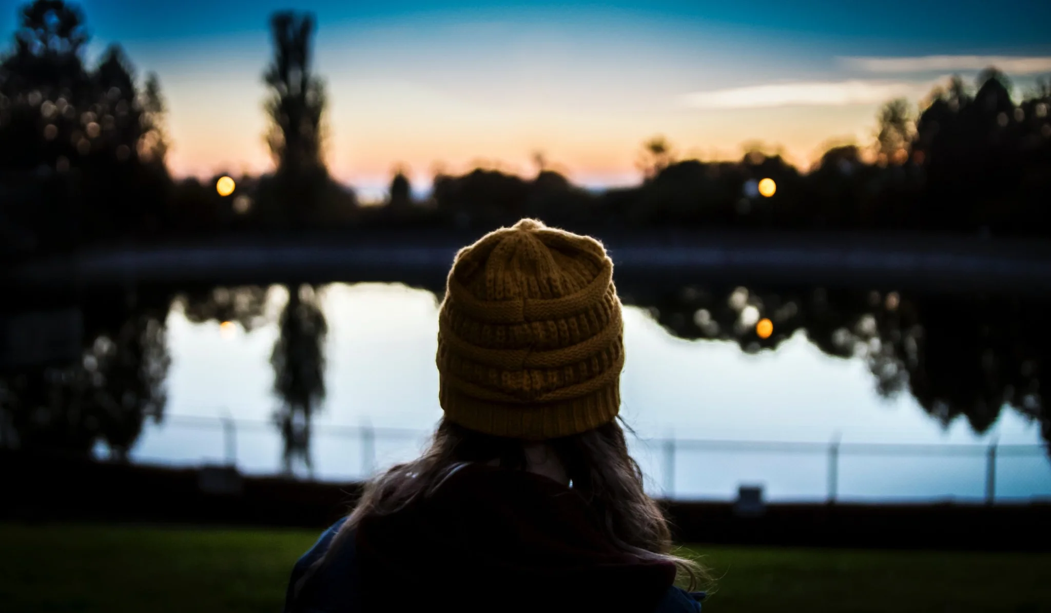 Young person watching the sunset over a river