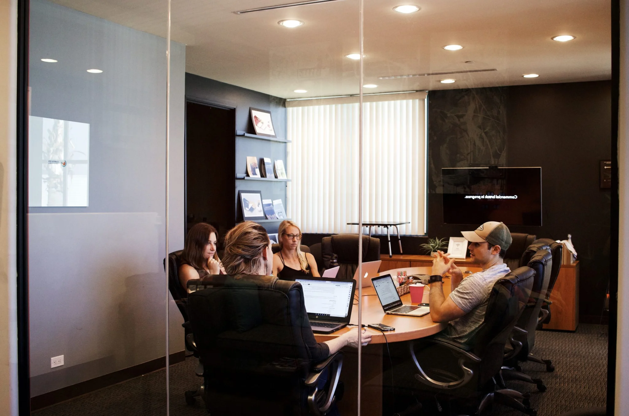 Young adults meeting in boardroom in front of their computers