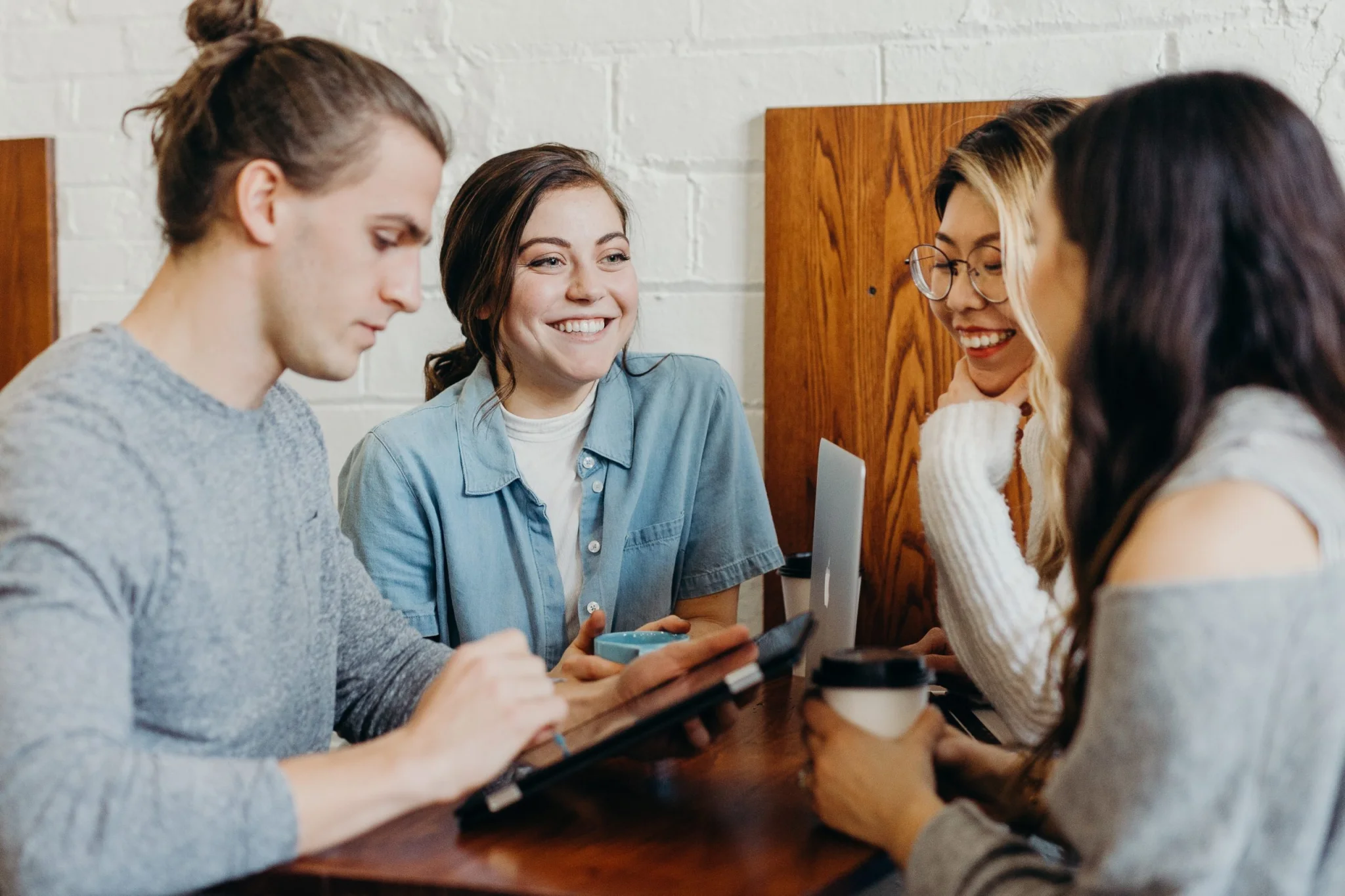 Four young people socialising at a cafe